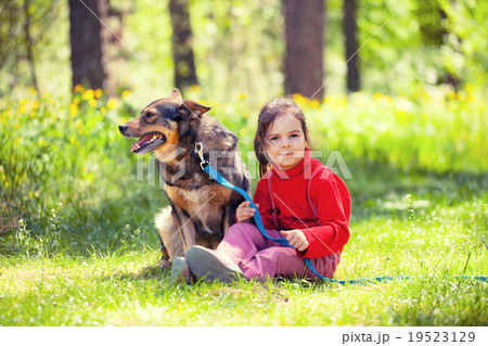 Happy little girl with big dog sitting in the lawn Happy little girl with big dog sitting in the lawn 19523129