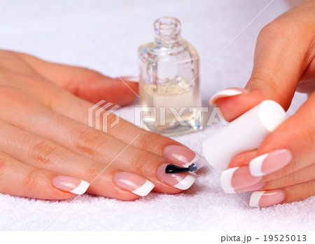 Woman applying nail polish Woman applying nail polish 19525013