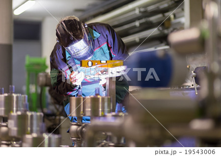 Industrial worker welding in metal factory. 19543006