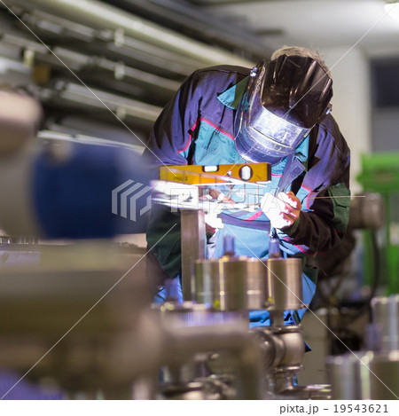 Industrial worker welding in metal factory. 19543621
