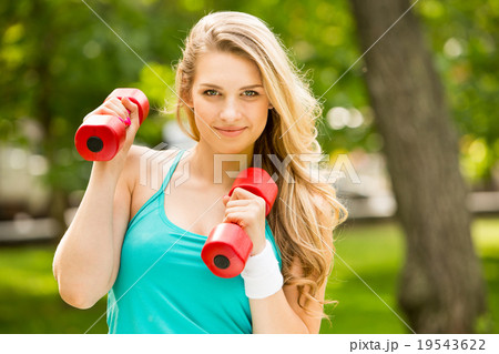 Sports girl exercise with  dumbbells in the park 19543622