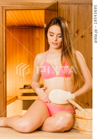 Woman in sauna with exfoliating glove. Skincare. Woman in sauna with exfoliating glove. Skincare. 19543695