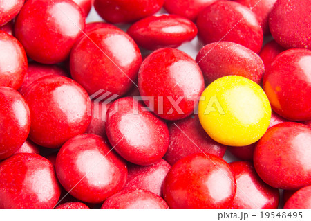 Focus on yellow chocolate candy against red 19548495