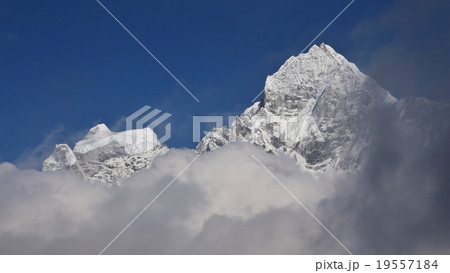 Peak of Mt Thamserku surrounded by clouds Peak of Mt Thamserku surrounded by clouds 19557184