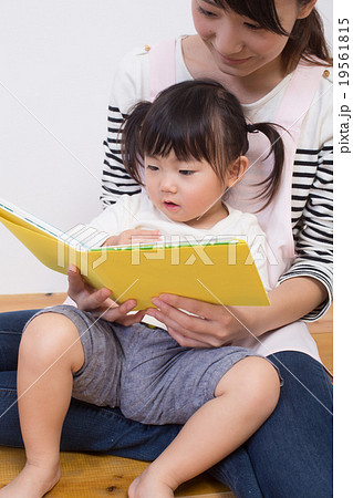 絵本を読み聞かせる保育士の写真素材