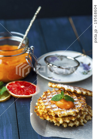 Wafers on baking paper with a jar of persimmon jam Wafers on baking paper with a jar of persimmon jam 19568604