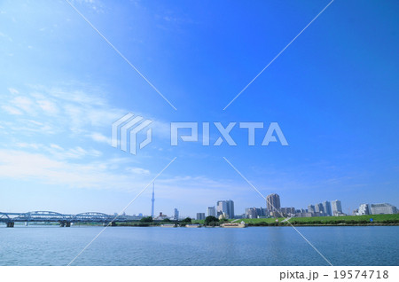 秋空とスカイツリーと荒川を望む京成線が走る堀切橋と水辺の風景 19574718