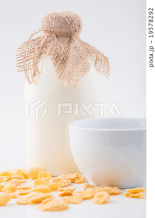 Bottle of milk, corn flakes and bowl. 19578292