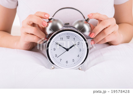 Female hands and alarm clock 19578428
