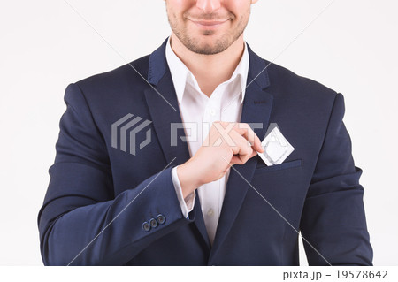 Smiling person putting condom into his breast Smiling person putting condom into his breast 19578642