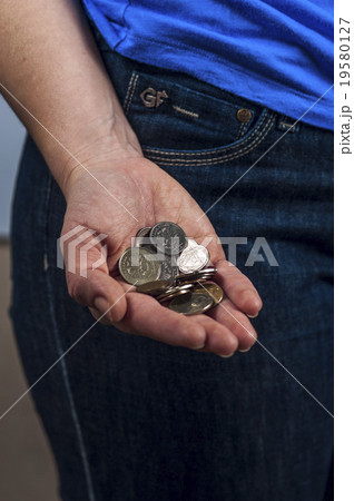 Woman in the blue t-shirt and jeans holds coins Woman in the blue t-shirt and jeans holds coins 19580127
