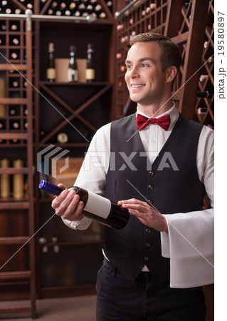 Attractive male winehouse worker is serving a 19580897