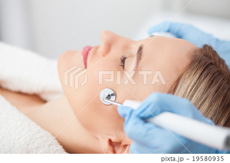 Cheerful blond girl is relaxing at beauty saloon 19580935