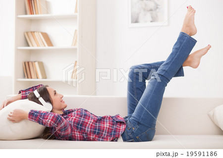 Cheerful young woman is resting at home Cheerful young woman is resting at home 19591186