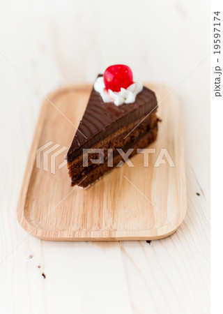 Chocolate cake slice on wooden plate. 19597174