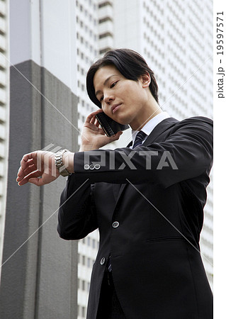 爽やか30代ビジネスマン スマホで会話 東京副都心 19597571