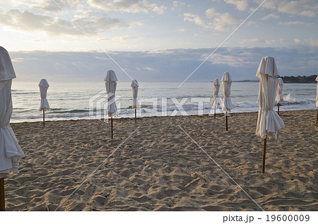 Beach umbrella on deserted coast sea at sunrise Beach umbrella on deserted coast sea at sunrise 19600009