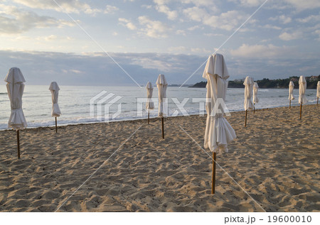 Beach umbrella on deserted coast sea at sunrise Beach umbrella on deserted coast sea at sunrise 19600010