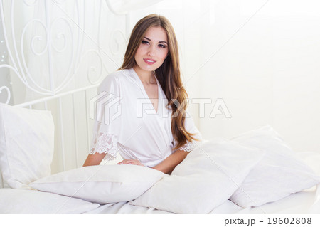 Pretty girl is sitting in white bed Pretty girl is sitting in white bed 19602808