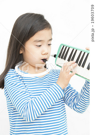 演奏する女の子 小学生 ピアニカを弾く女の子 パーツカット ボディパーツの写真素材