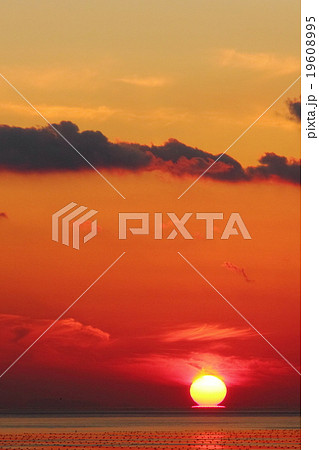 瀬戸内の播磨灘に燃え上がる幻想的なだるま夕日・夕焼けと浮島 19608995