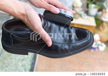 Hands polish leather black shoes. 19638993