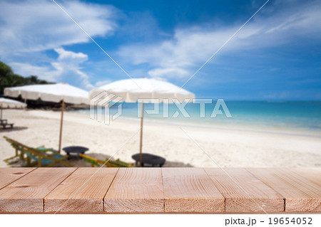 Wood table on blurred blue sea and white sandbeach Wood table on blurred blue sea and white sandbeach 19654052