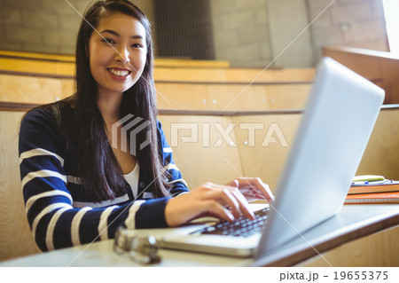 Smiling student using laptop Smiling student using laptop 19655375