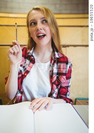 Blonde student asking a question during class 19655520