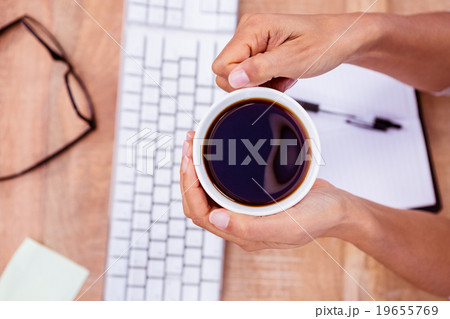 Businesswoman holding black coffee cup 19655769