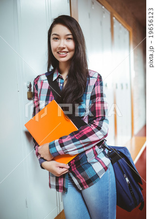 Cheerful student standing next the locker Cheerful student standing next the locker 19656123