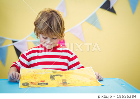 Smiling child holding his finished painting 19656284