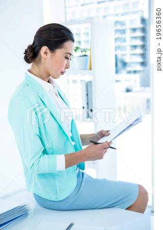 Smiling businesswoman using her notes 19656360