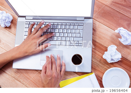 Part of hands typing on laptop 19656404