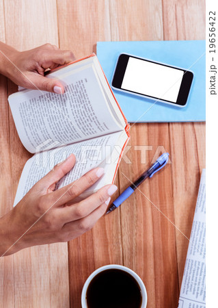 Overhead of feminine hands holding a book 19656422