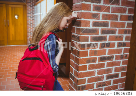 Worried student leaning against the wall 19656803