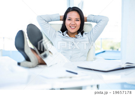 Smiling businesswoman relaxing herself Smiling businesswoman relaxing herself 19657178