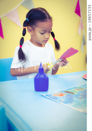 Focused girl cutting a paper plate 19657235