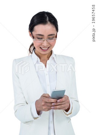Smiling businesswoman using her smart phone 19657458