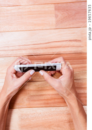 Part of hands holding smartphone 19657635