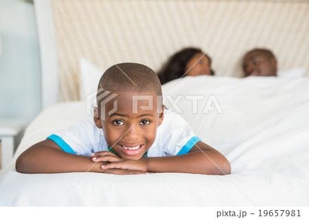 Smiling son lying on bed  19657981