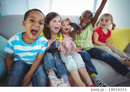 Happy kids laughing while sitting down Happy kids laughing while sitting down 19659333