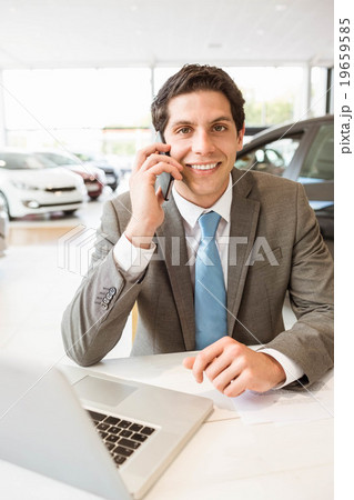 Smiling salesman having a phone call 19659585