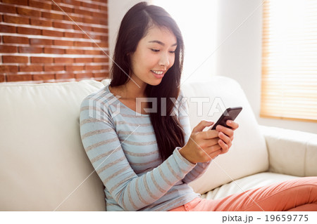 Asian woman reading text on couch Asian woman reading text on couch 19659775