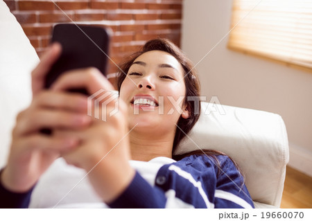 Asian woman laughing on the phone Asian woman laughing on the phone 19660070