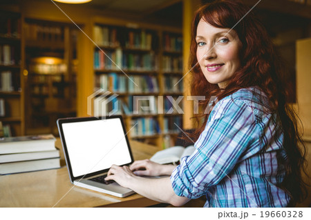 Mature student studying in library with laptop 19660328