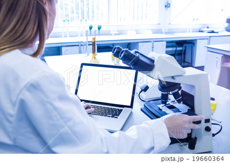 Scientist working with a microscope in laboratory Scientist working with a microscope in laboratory 19660364