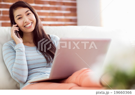Asian woman on the phone using laptop 19660366