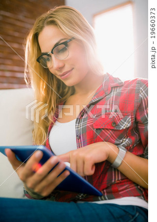 Pretty blonde using tablet on couch 19660373