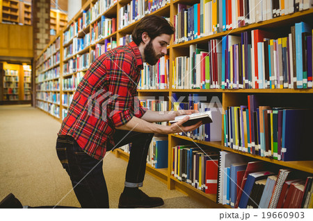 Student picking a book from shelf in library 19660903